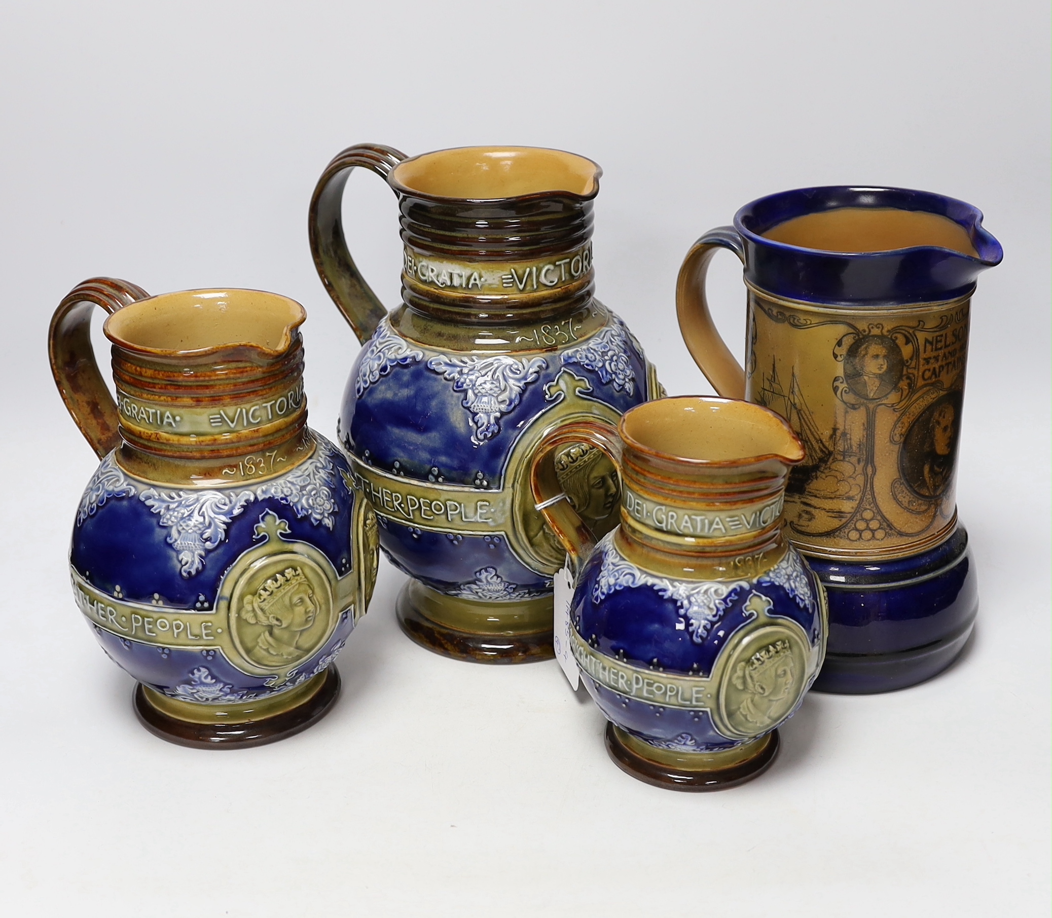 Three graduated Doulton Lambeth Queen Victoria diamond Jubilee commemorative jugs and a Nelson and his captains commemorative jug, largest 21cm high